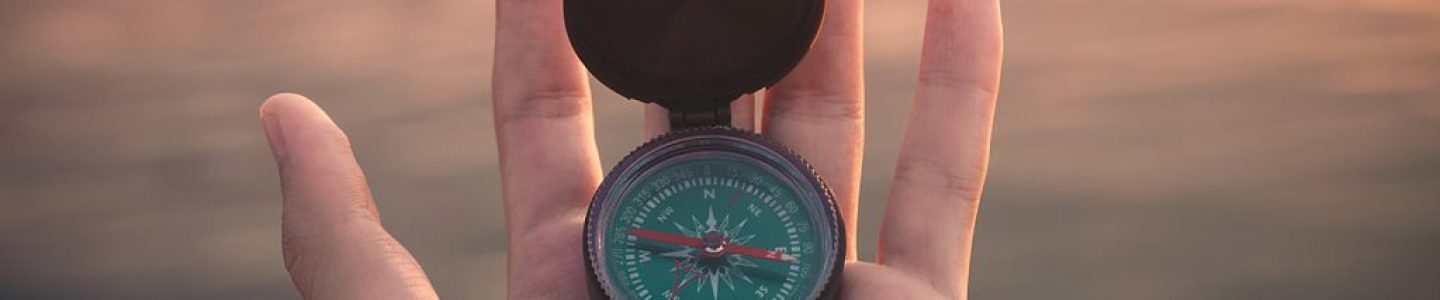 Close-up of mans hand holding a compass.