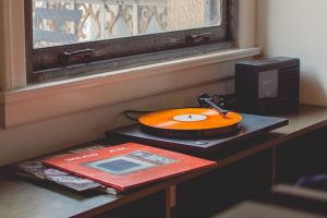 An orange record playing on a classic turntable.